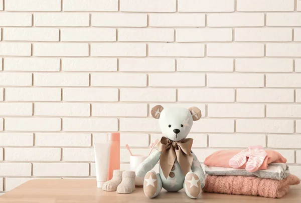 Toy Bear Baby Clothes Accessories Table White Brick Wall — Stock Photo, Image