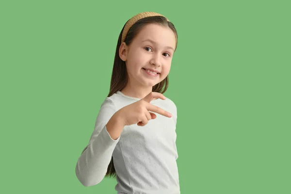 Schattig Klein Meisje Maken Hart Met Haar Hand Groene Achtergrond — Stockfoto