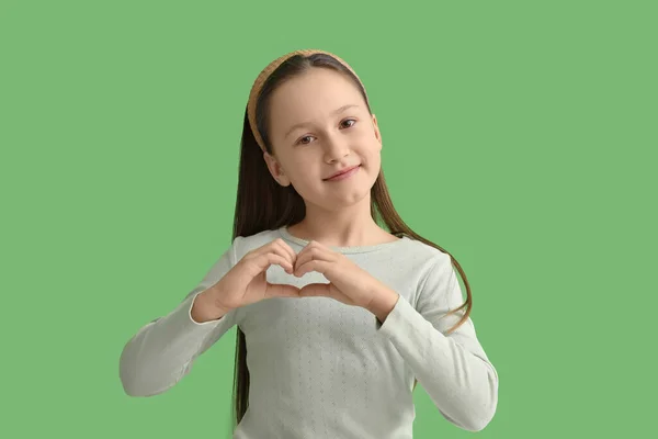 Cute Little Girl Serce Jej Rąk Zielonym Tle — Zdjęcie stockowe