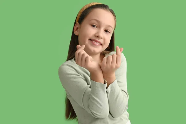Cute Little Girl Serce Palcami Zielonym Tle — Zdjęcie stockowe