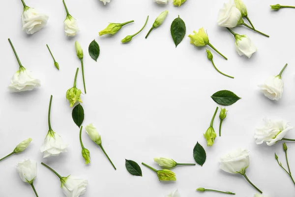 Çok Güzel Eustoma Çiçeklerinden Açık Arkaplanda Bitki Yapraklarından Yapılmış Çerçeve — Stok fotoğraf