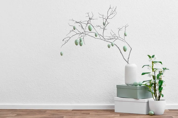 木の枝 イースターエッグと光の壁の近くの観葉植物の花瓶 — ストック写真