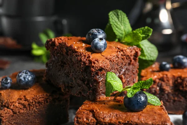 stock image Pieces of tasty chocolate brownie on black background, closeup