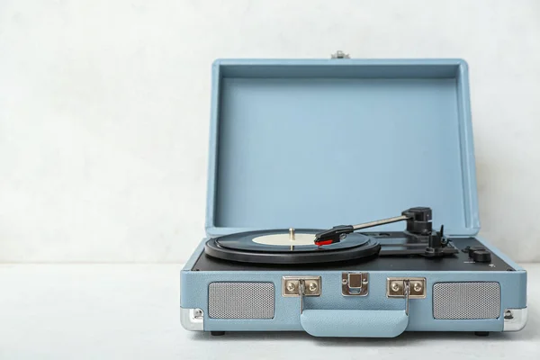 Record player with vinyl disk on white table