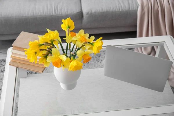 現代のラップトップ ナルシシズムの花の花瓶 リビングルームのガラスコーヒーテーブルの本 — ストック写真