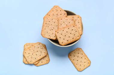 Mavi arka planda lezzetli krakerler olan kase
