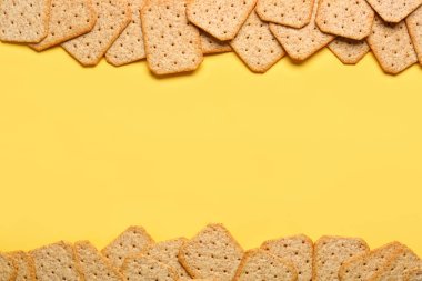 Sarı arka planda lezzetli krakerlerden yapılmış çerçeve