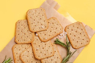 Lezzetli krakerli parşömen, biberiye ve tuz sarı arka planda