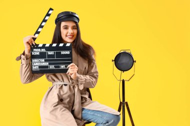Sarı arka planda film alkışları olan kadın film yönetmeni