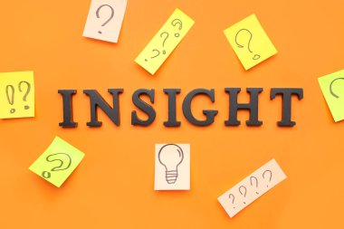 Kelime INSIGHT, kağıtlar kırmızı arka planda çizilmiş soru işaretleri ve ampul