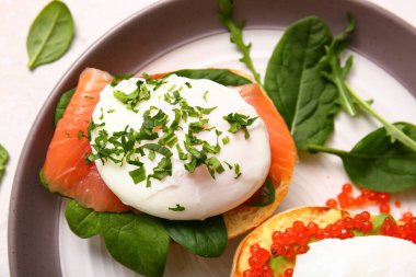 Benedict yumurtalı tabak beyaz masada, yakın plan.