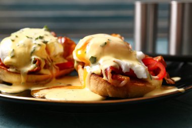 Plate with tasty eggs Benedict on grey grunge table, closeup clipart