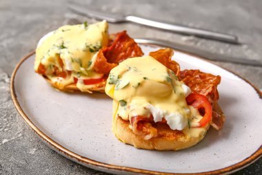 Gri grunge masasında lezzetli yumurtalı Benedict tabağı.