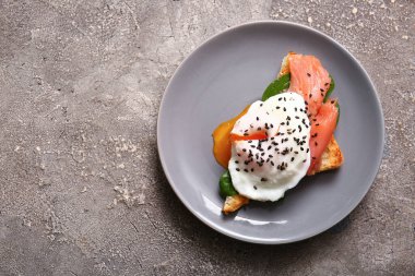 Gri grunge masasında lezzetli yumurtalı Benedict.