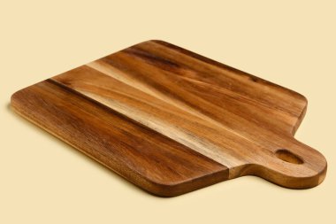 Sarı arkaplanda tahta kesme tahtası, yakın plan.