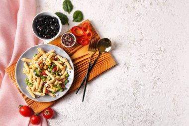 Lezzetli makarna salatası ve hafif arka planda malzemeler.