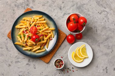 Lezzetli makarna salatası ve arkaplandaki malzemelerle dolu bir tabak.