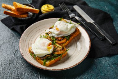 Siyah arka planda lezzetli yumurtalı Benedict tabağı.