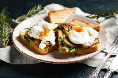 Siyah arka planda lezzetli yumurtalı Benedict tabağı.