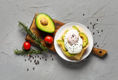 Gri arka planda lezzetli yumurta Benedict tabağı.