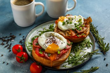 Mavi arka planda lezzetli yumurtalı Benedict tabağı.