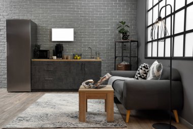 Siyah kanepesi ve tezgahı olan modern mutfağın içi.