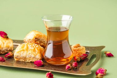 Bir bardak çay, Türk lezzeti ve arka planda kurumuş güller.