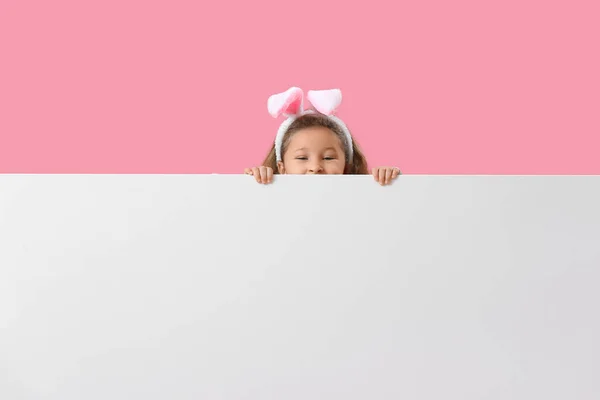 Dziewczynka Króliczych Uszach Pustym Plakatem Różowym Tle Wielkanoc — Zdjęcie stockowe