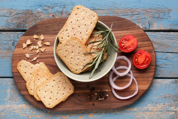 Board Tasty Crackers Rosemary Onion Tomatoes Blue Wooden Background — Stock Photo, Image