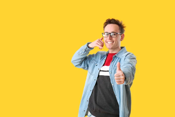 Cool Young Man Talking Imaginary Phone Showing Thumb Yellow Background — Stock Photo, Image