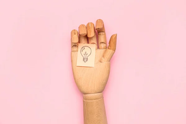 ピンクの背景に電球を描いた木製の手と粘着性のある紙 洞察の概念 — ストック写真