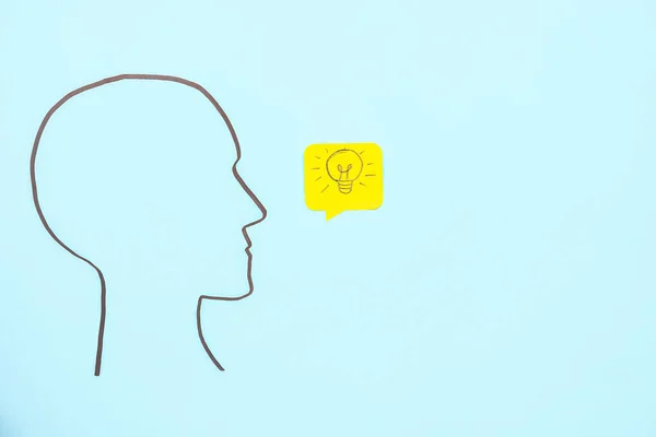 Drawn human head and speech bubble with light bulb on blue background. Insight concept