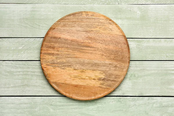 stock image Round cutting board on color wooden background