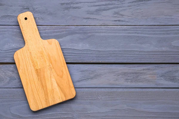 Kitchen board on color wooden background