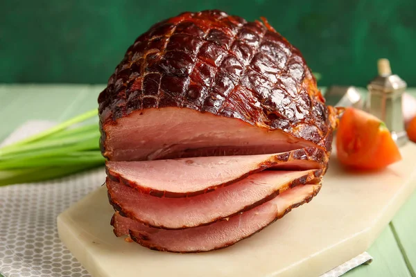 Board with tasty smoked ham on table