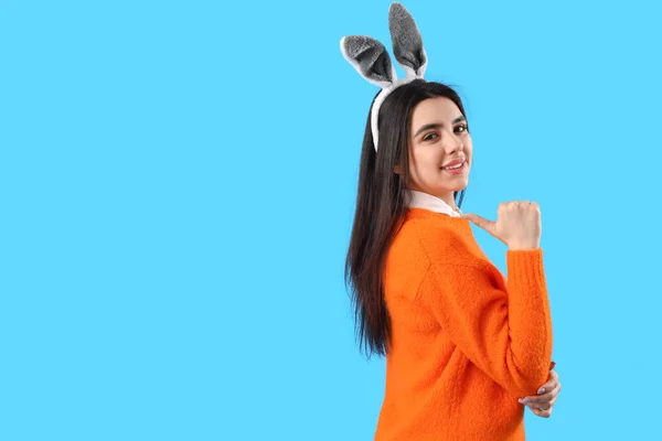 Mujer Joven Con Orejas Conejo Señalando Algo Sobre Fondo Azul —  Fotos de Stock