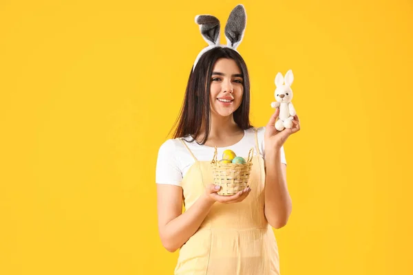 Молода Жінка Вухах Кролика Кошиком Великодніх Яєць Жовтому Фоні — стокове фото
