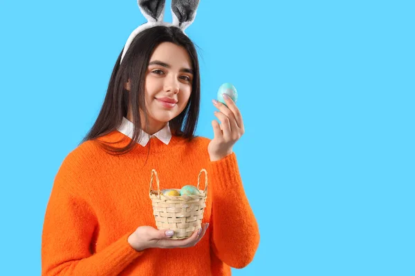 Mladá Žena Králičí Uši Košíkem Velikonočních Vajec Modrém Pozadí — Stock fotografie