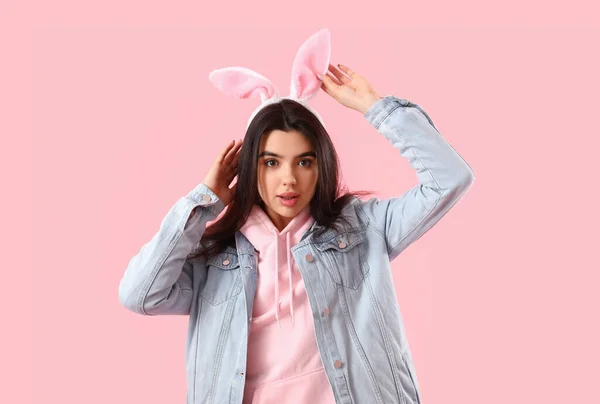 穿着粉红背景的兔子耳朵的年轻女人 复活节庆祝活动 — 图库照片