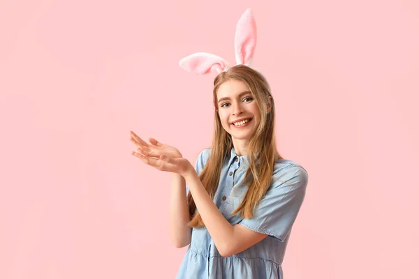 Молода Жінка Кролячих Вухах Показує Щось Рожевому Тлі Великоднє Святкування — стокове фото