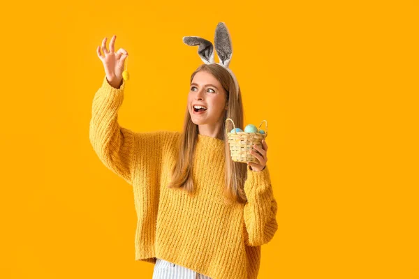 Glückliche Junge Frau Hasenohren Mit Korb Voller Ostereier Auf Gelbem — Stockfoto