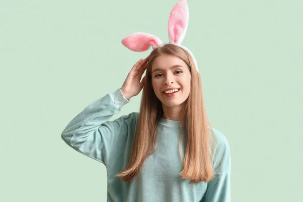 緑の背景にウサギの耳の若い女性 イースターのお祝い — ストック写真
