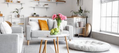 Taze elmalı sepet ve laleli vazo aydınlık odada.