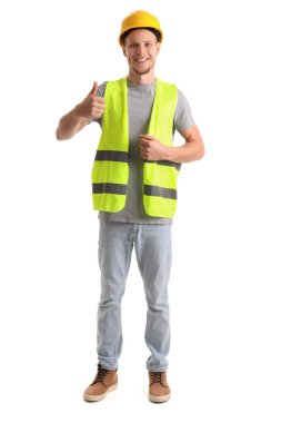 Yelekli ve kasklı bir erkek işçi beyaz arka planda baş parmak gösteriyor.