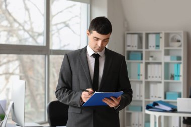 Young accountant with document in office