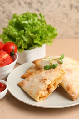 Fırında pişmiş et, domates ve marullu tabak. Renkli masa, yakın plan.