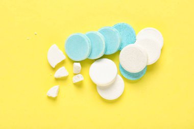 Sarı zemin üzerinde mavi ve beyaz çözünebilir tabletler