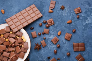 Lezzetli çikolata parçaları ve koyu renk arka planda şekerler içeren kompozisyon