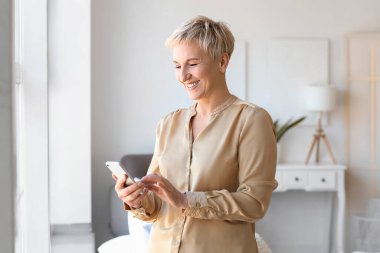 Olgun kadın evde cep telefonunuzun