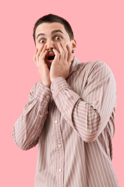 Pembe arka plandaki korkmuş genç adam